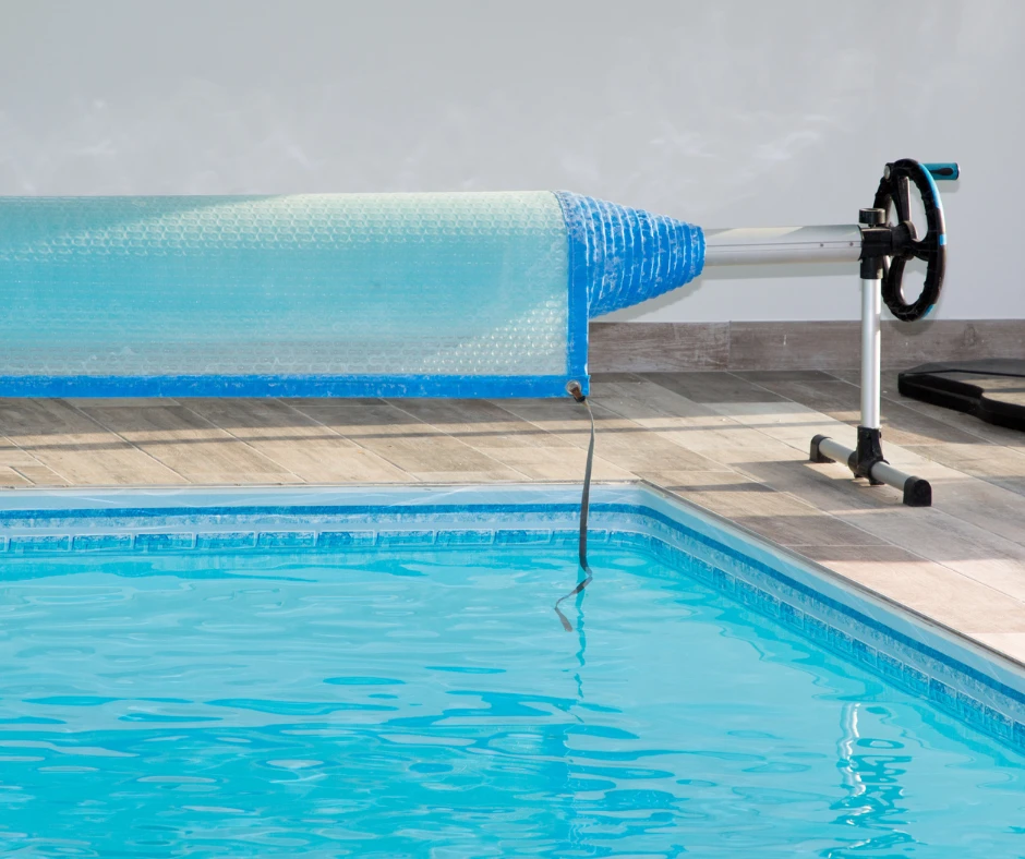 Une bache de piscine, enroulées sur un système qui permet de replier la bache facilement dans le Genevois