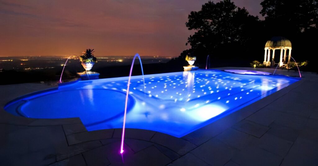 Une piscine éclairée par un système de LED et d'éclairage sous-marin par MSR Piscines à Genève.